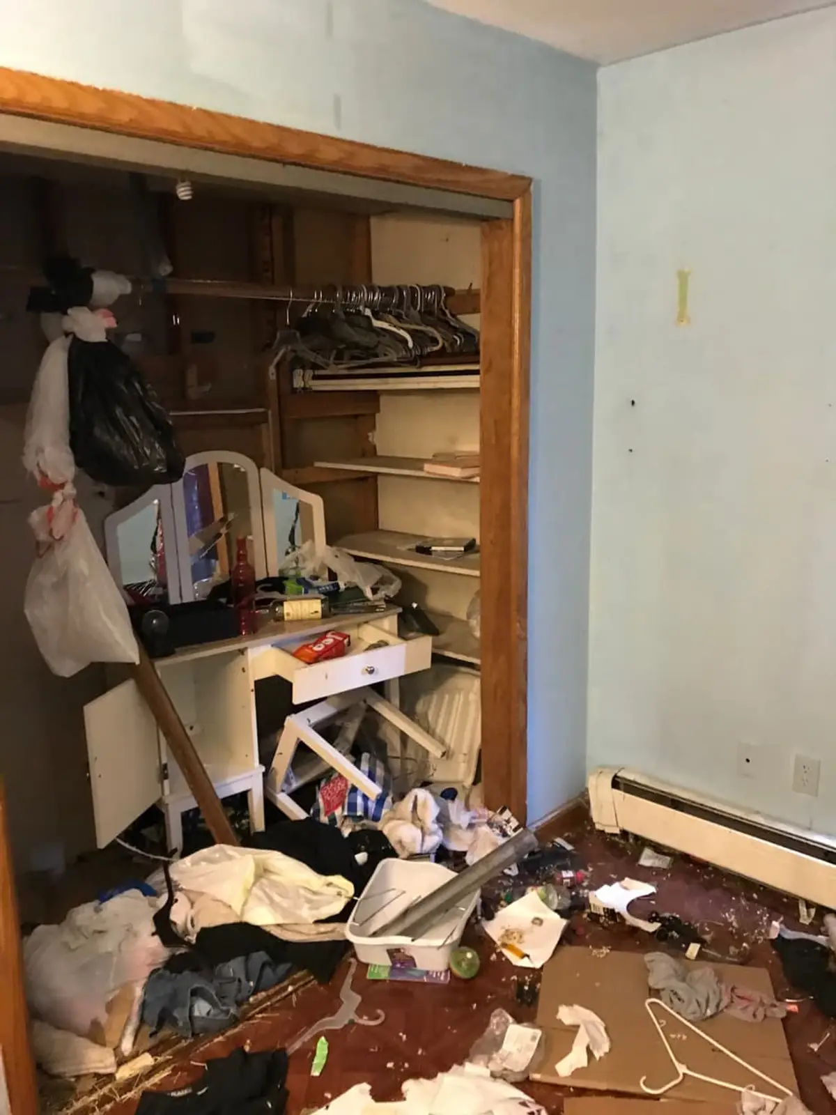 Dealing with squatters or holdover tenants in Shirley: bedroom closet spilling clothes and trash onto the floor