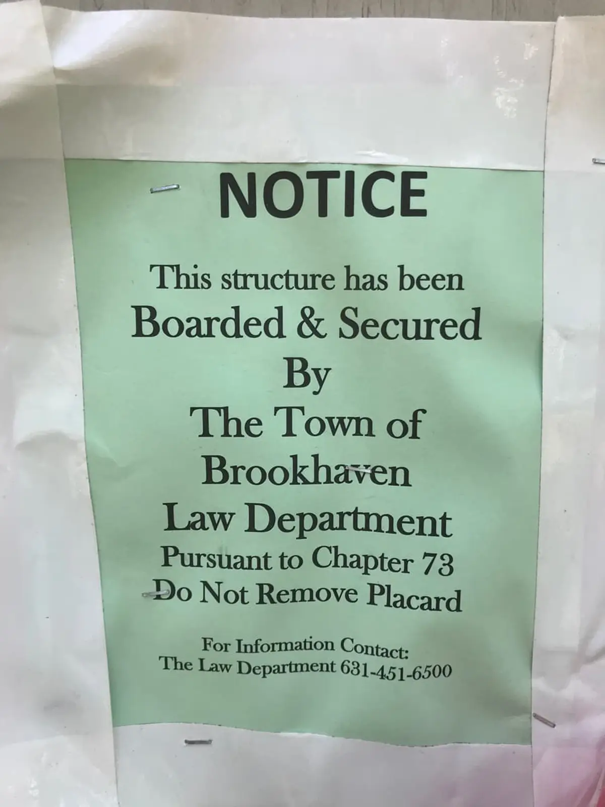 Selling a condemned house in Shirley: boarded and secured notice posted by the town