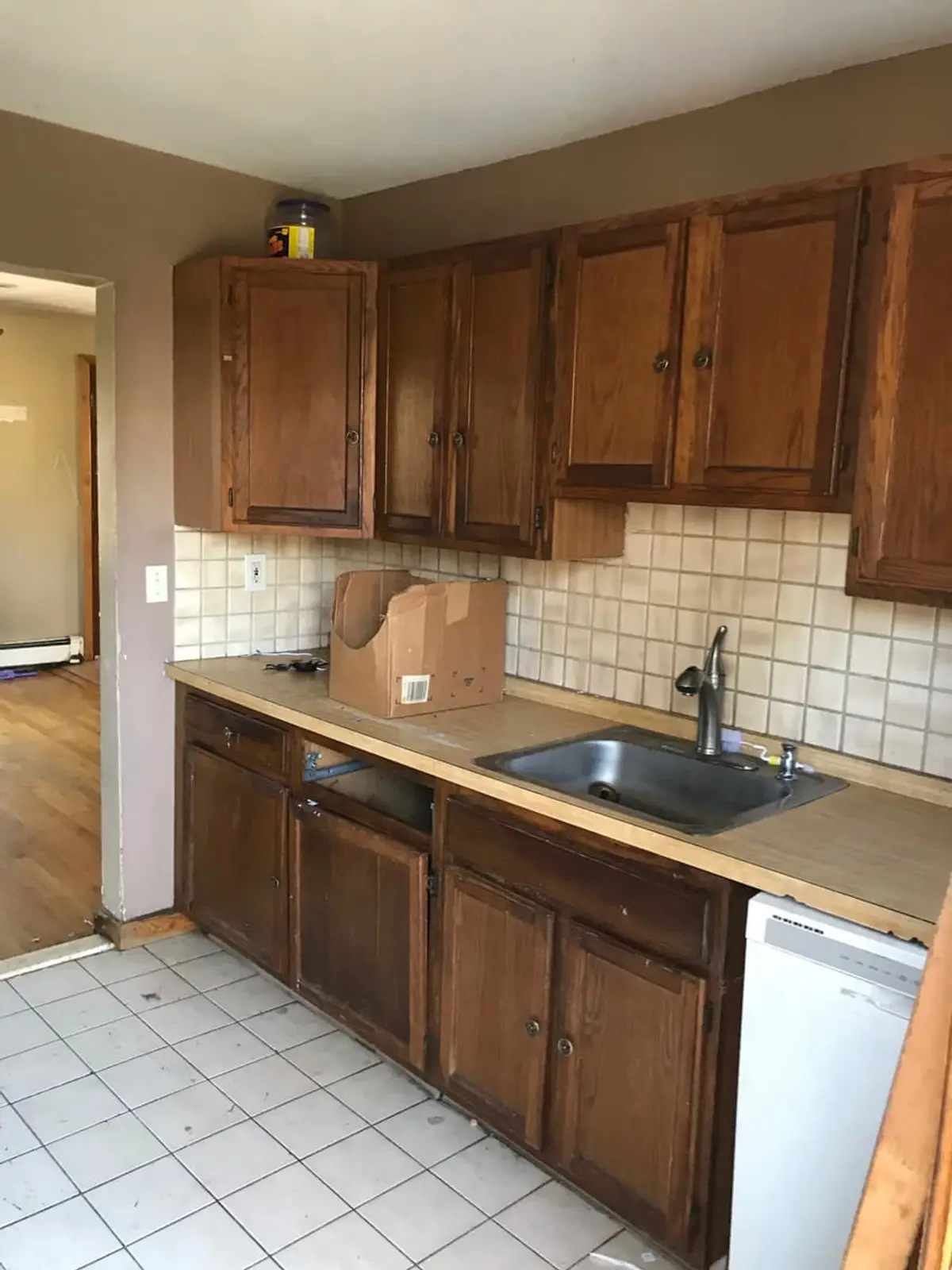 Downsizing or retiring in Shirley: dated kitchen with dark oak cabinets and tile backsplash