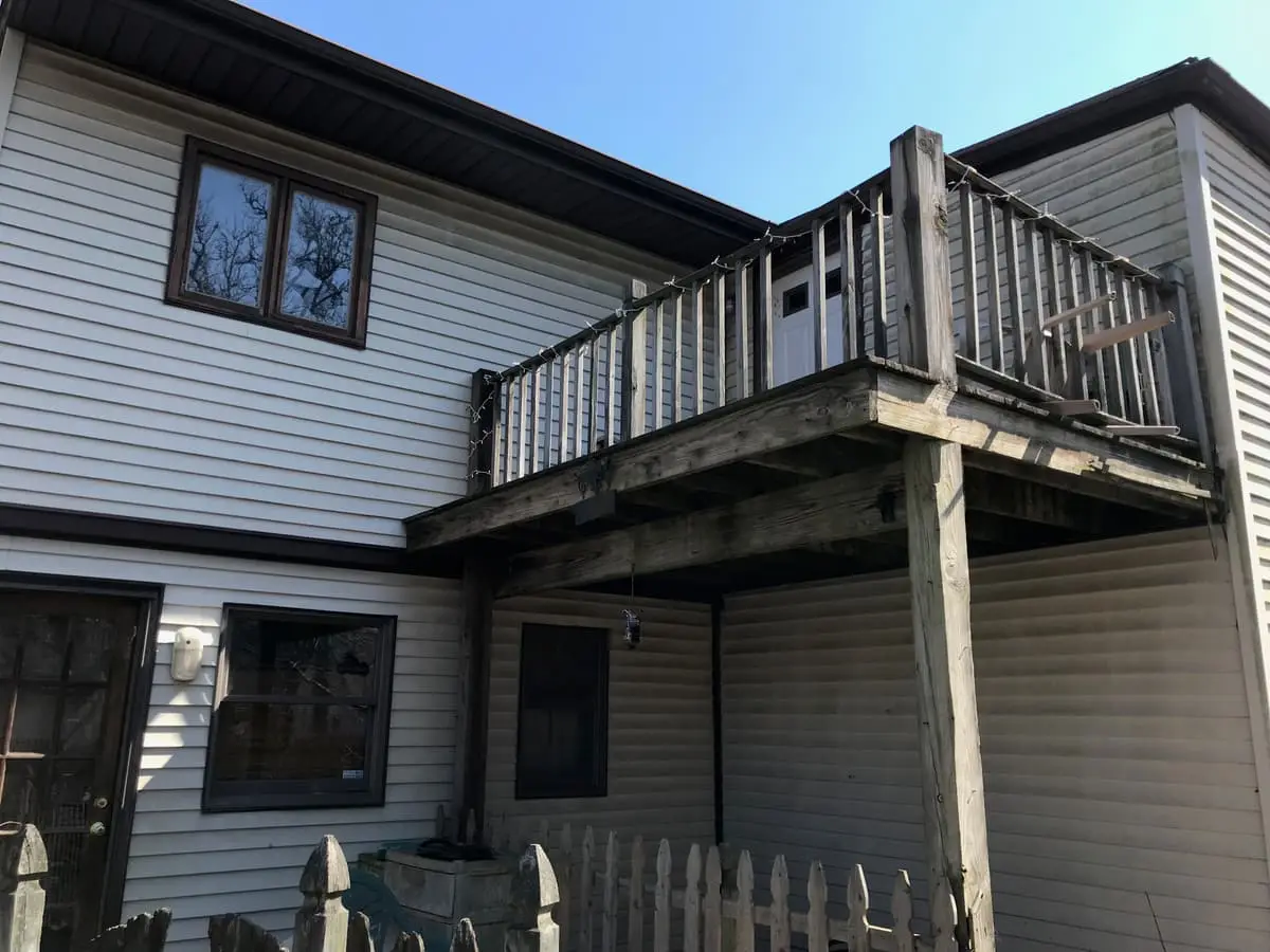 Selling estate property as an executor in Shirley: rear of a two story house with a wood balcony