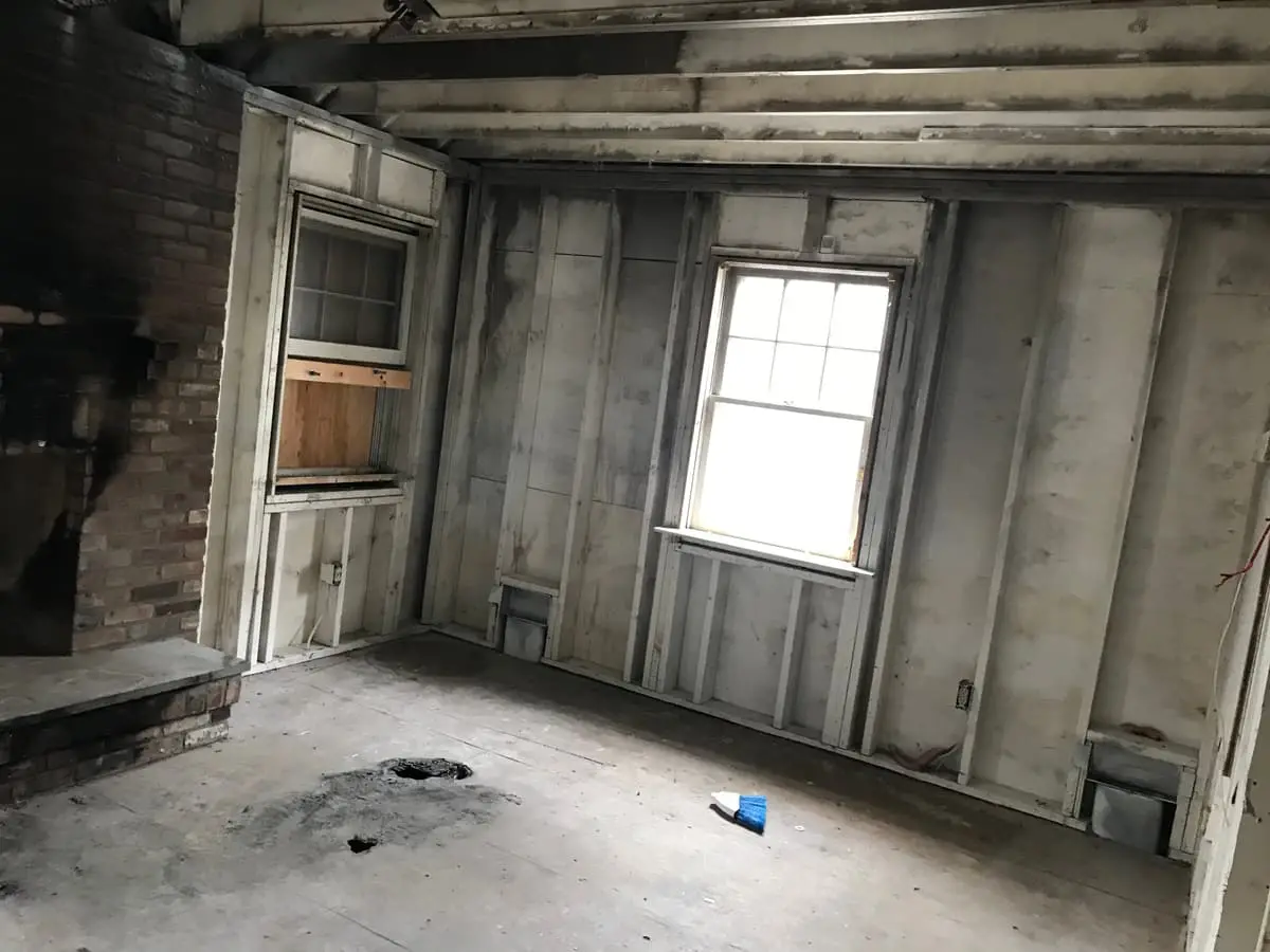 Selling a house with unpermitted work in Shirley: room stripped to the studs beside a brick fireplace