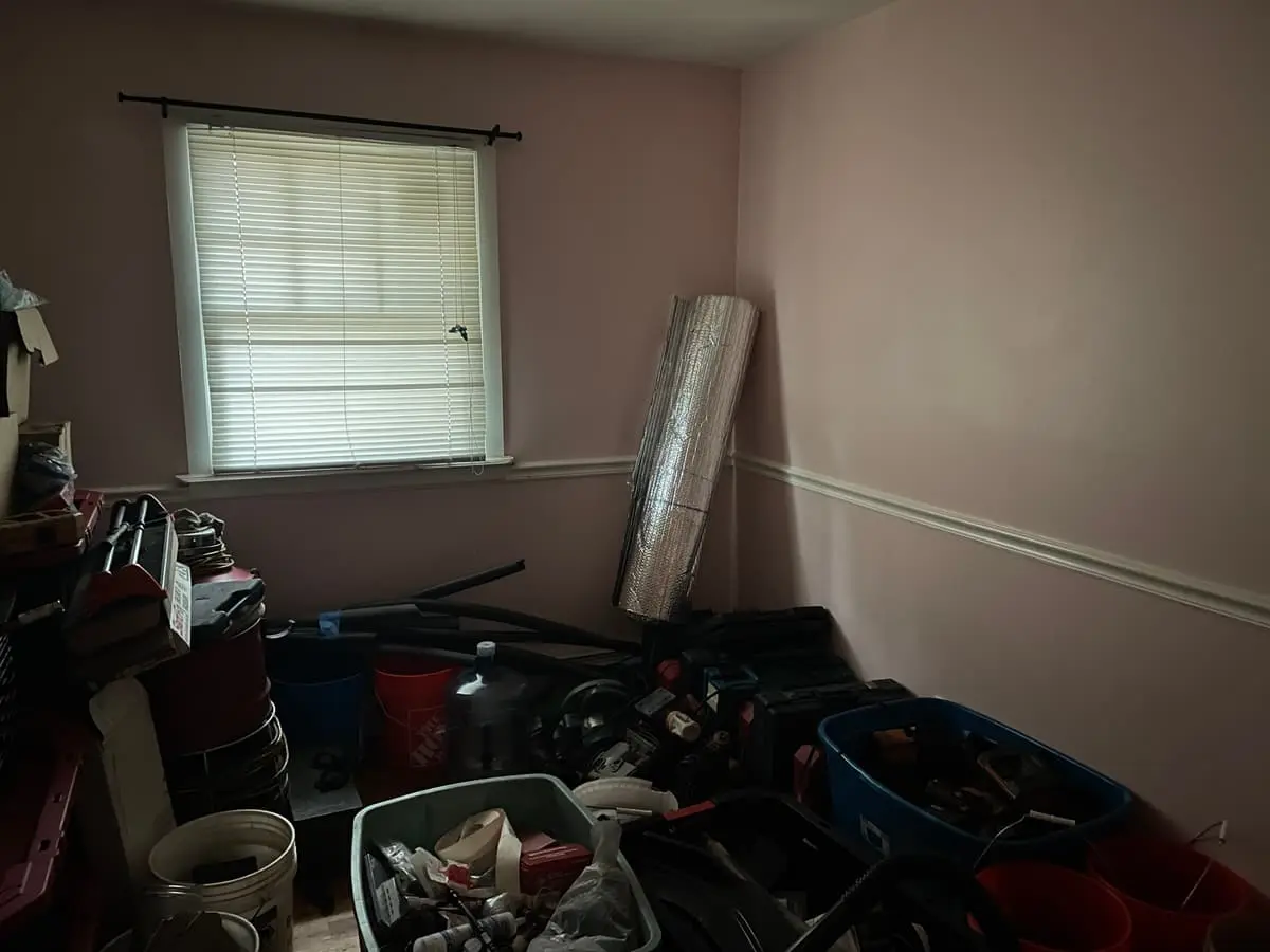 Selling a house during a divorce in Shirley: spare room packed with bins, buckets and tools